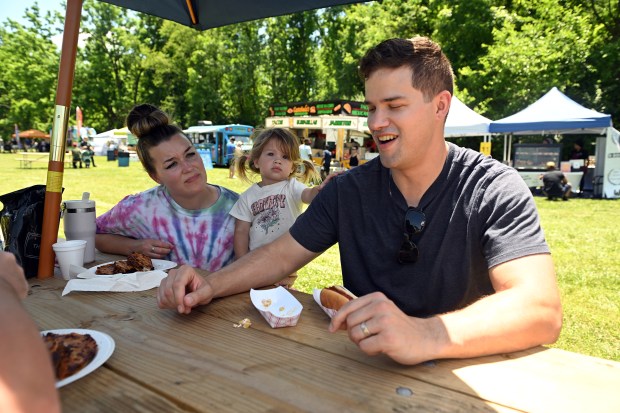 Joseph and Lisa Martin of Ephrata enjoy food with their daughter Ellen, 2, during the Spring Fiesta at Jim Dietrich Park in Muhlenberg Township, (BILL UHRICH/READING EAGLE)