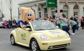 Mrs. Tâs Pierogies mascot Mr. Pierogyman rides down Main Street...