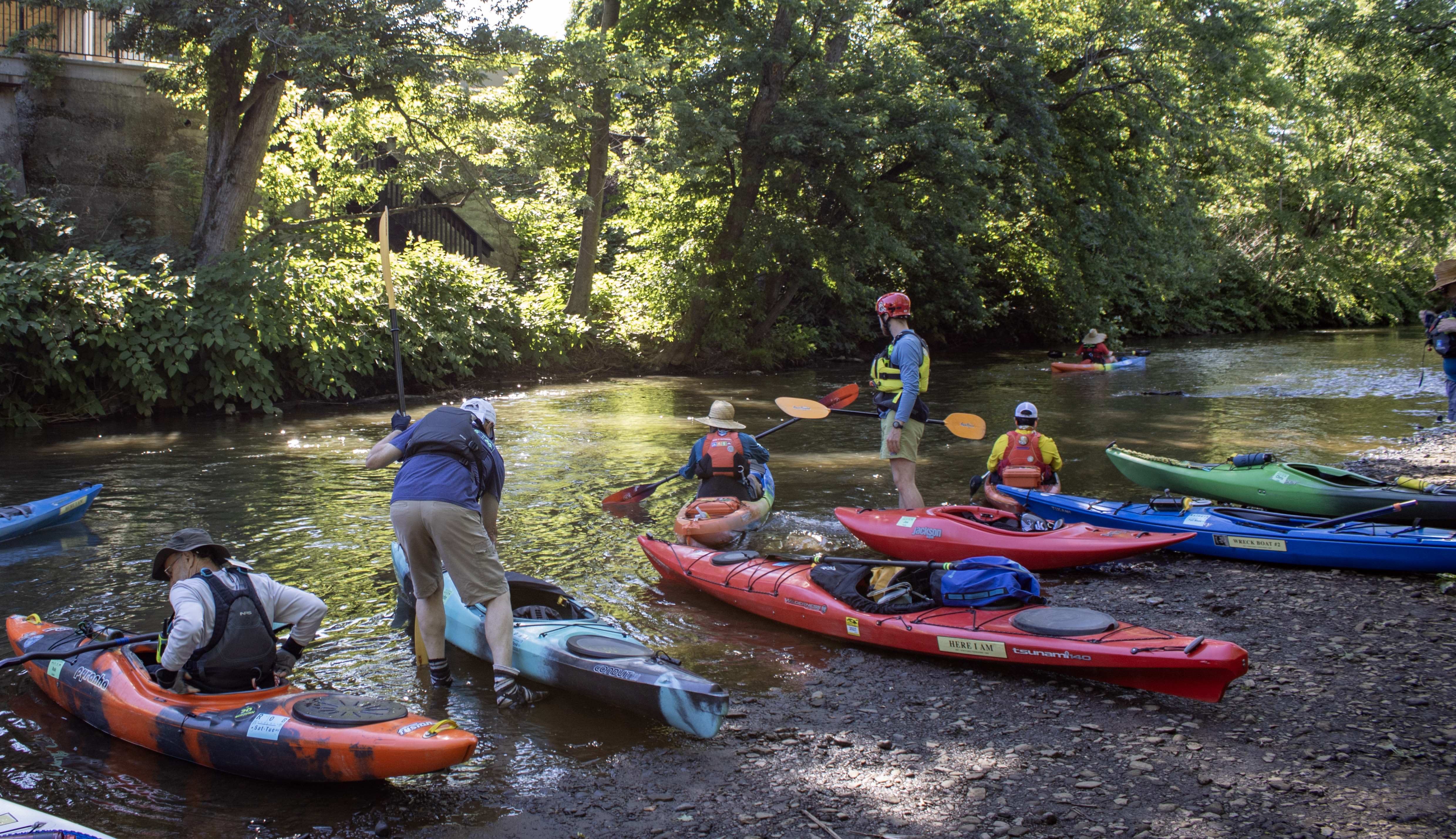 Kayakers step into the shallows and launch their boats during...