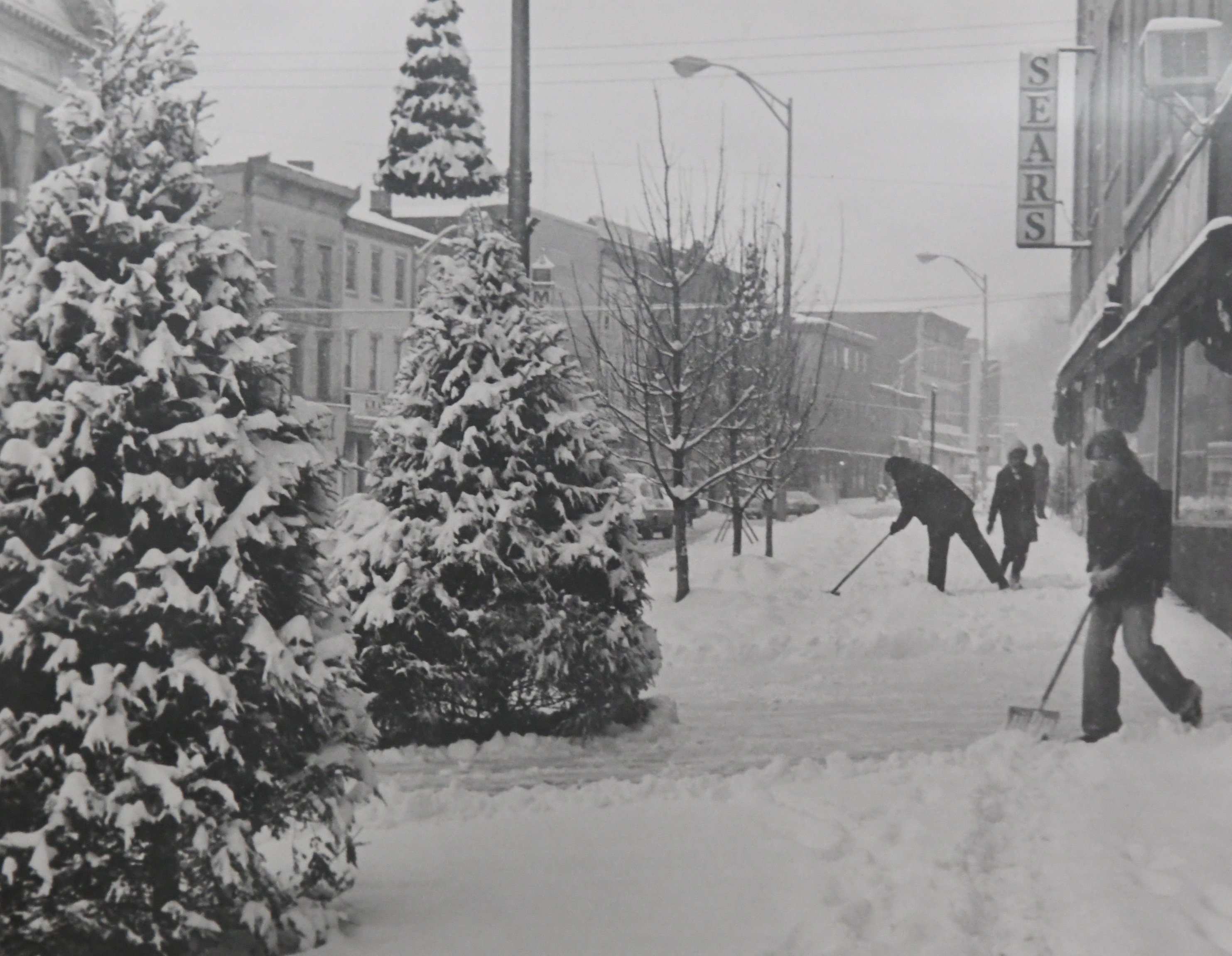 Shoveling snow on Centre Street in front of Sears in...