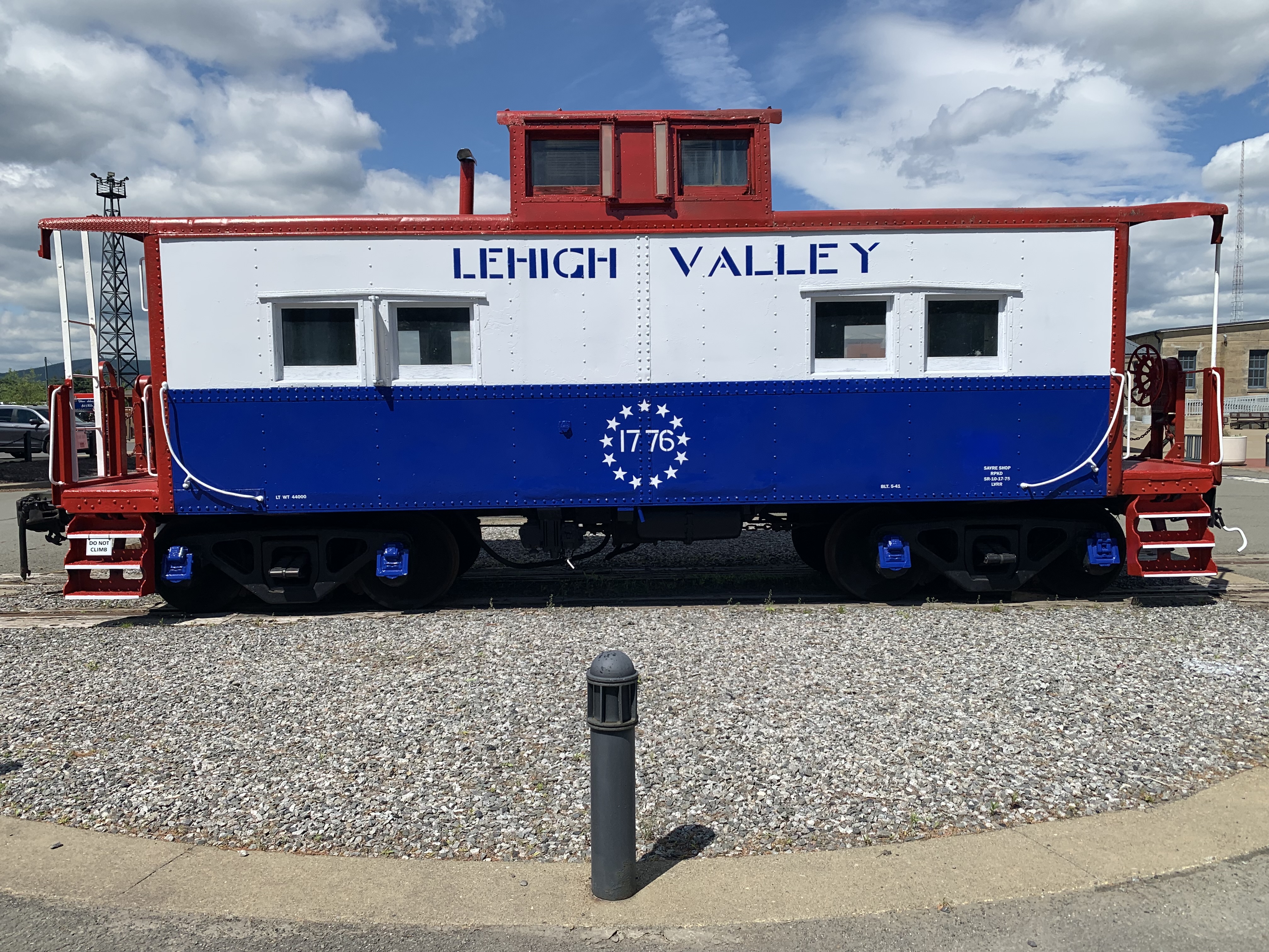 A caboose painted red, white and blue and with “Lehigh...