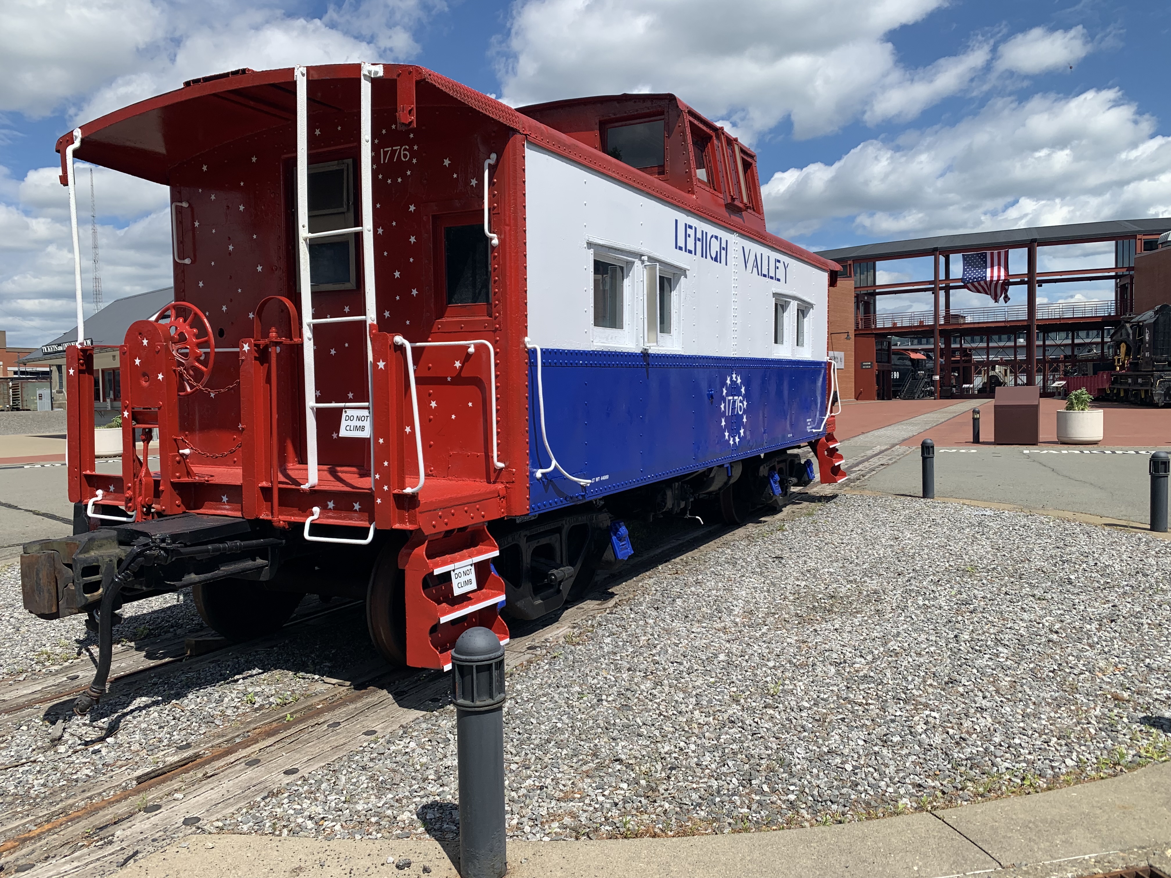 A caboose painted red, white and blue and with “Lehigh...