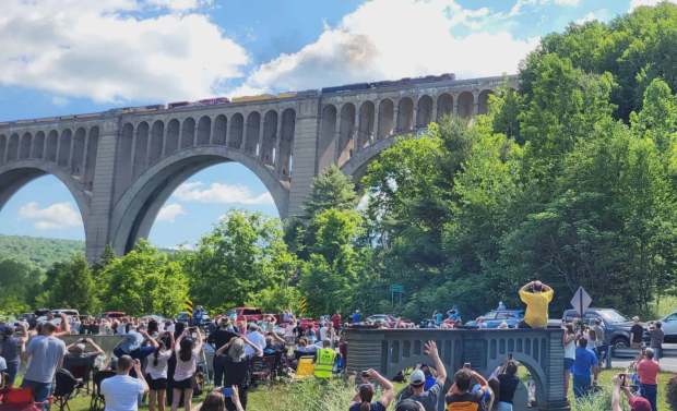 Those attending the Big Boy's crossing over the Tunkhannock Viaduct on Saturday, June 13, 2026, cheer and raise their cameras and cell phones to capture the historic moment. (GERI GIBBONS/STAFF PHOTO)
