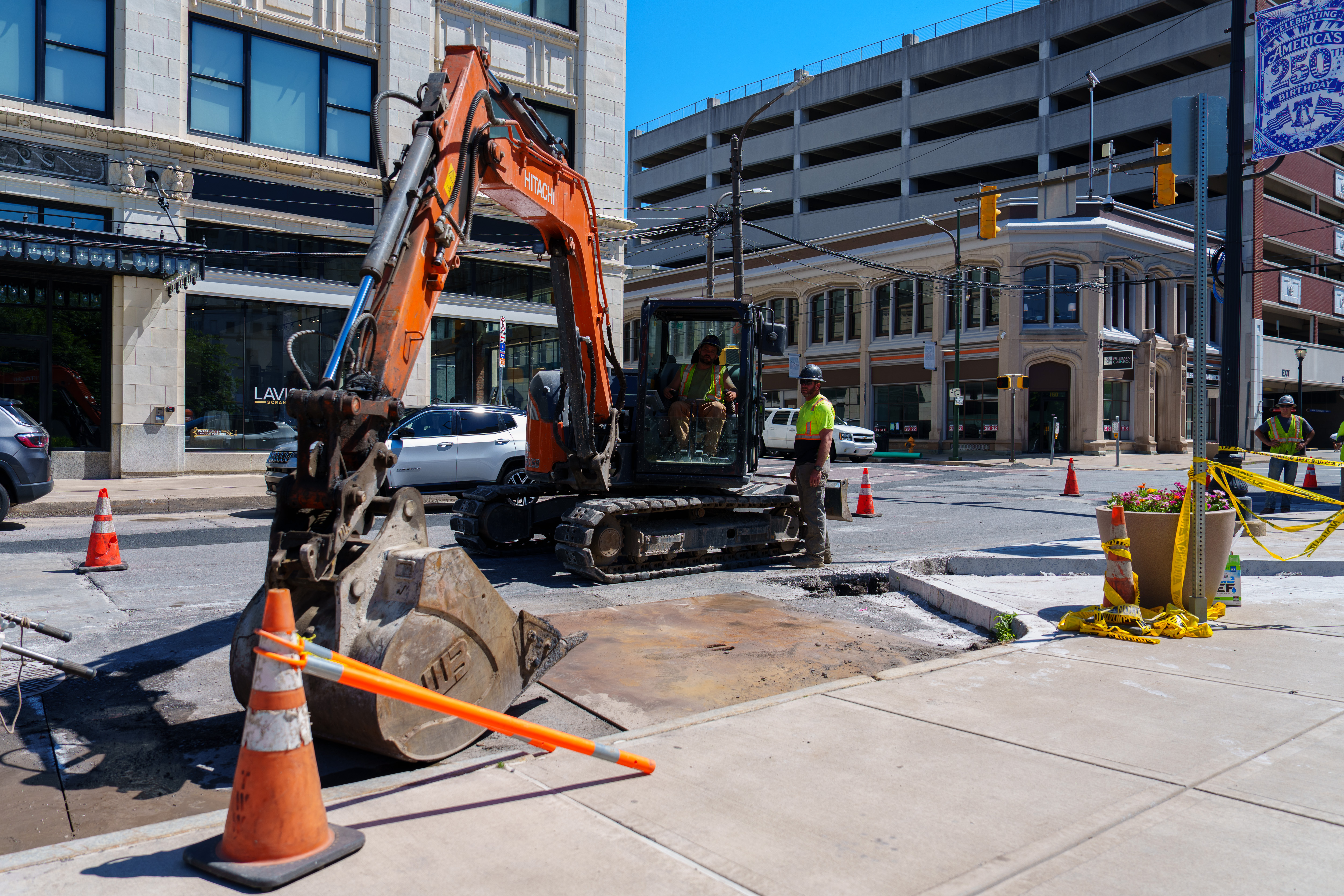 An excavator attaches a digging bucket to its arm on...