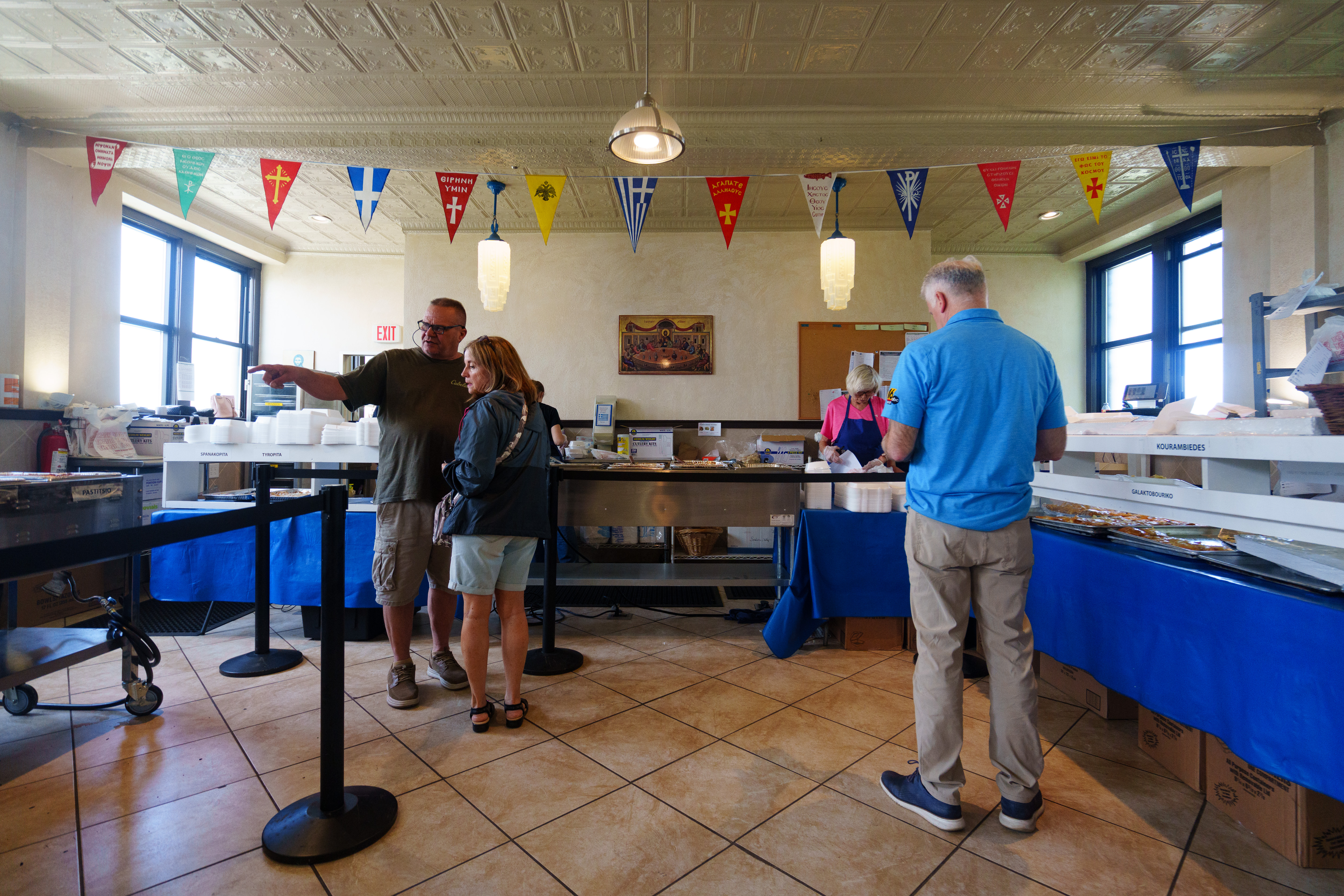 Customers wait in line for food at the Greek Food...