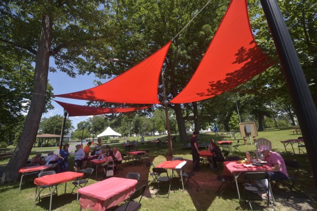 People relax under new red canopies at the 2026 Jewish Food Festival, a four-day celebration of Jewish ethnic food at Nay Aug Park in Scranton from Sunday, June 28, through Wednesday, July 1, from 11:30 a.m. to 6:30 p.m. daily. (CHAD SEBRING/STAFF PHOTO)