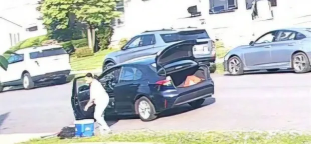 Shown is a woman who picking up a blue cooler from outside the Hebrew Day School in the Hill Section at 7:49 a.m. on Friday, June 5, 2026. The cooler contained religious items which the owners are hoping to get back. (SUBMITTED)