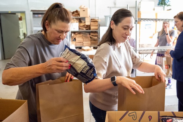 Volunteer Lola Kranick, left, and Vice President Kristen Warholic, right, pack bags at the Valley Village of Volunteers' food pantry in the Dickson City Community Building on Thursday, May 28, 2026. (REBECCA PARTICKA/STAFF PHOTOGRAPHER)