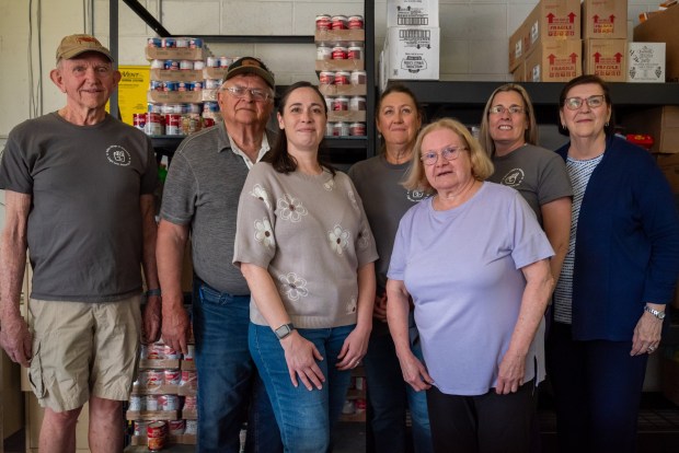(Left to right) Valley Village of Volunteers members Victor Milani, Treasurer Jack Horvath, Vice President Kristen Warholic, Lola Kranick, Mary Ann Eglesia, Debbie Borusiewicz and Mariella Selvenis pose in the group's food pantry at the Dickson City Community Building on Thursday, May 28, 2026. (REBECCA PARTICKA/STAFF PHOTOGRAPHER)