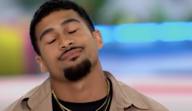 Sean Reifel, a man with a goatee and gold chains, closes his eyes and tilts his head slightly.