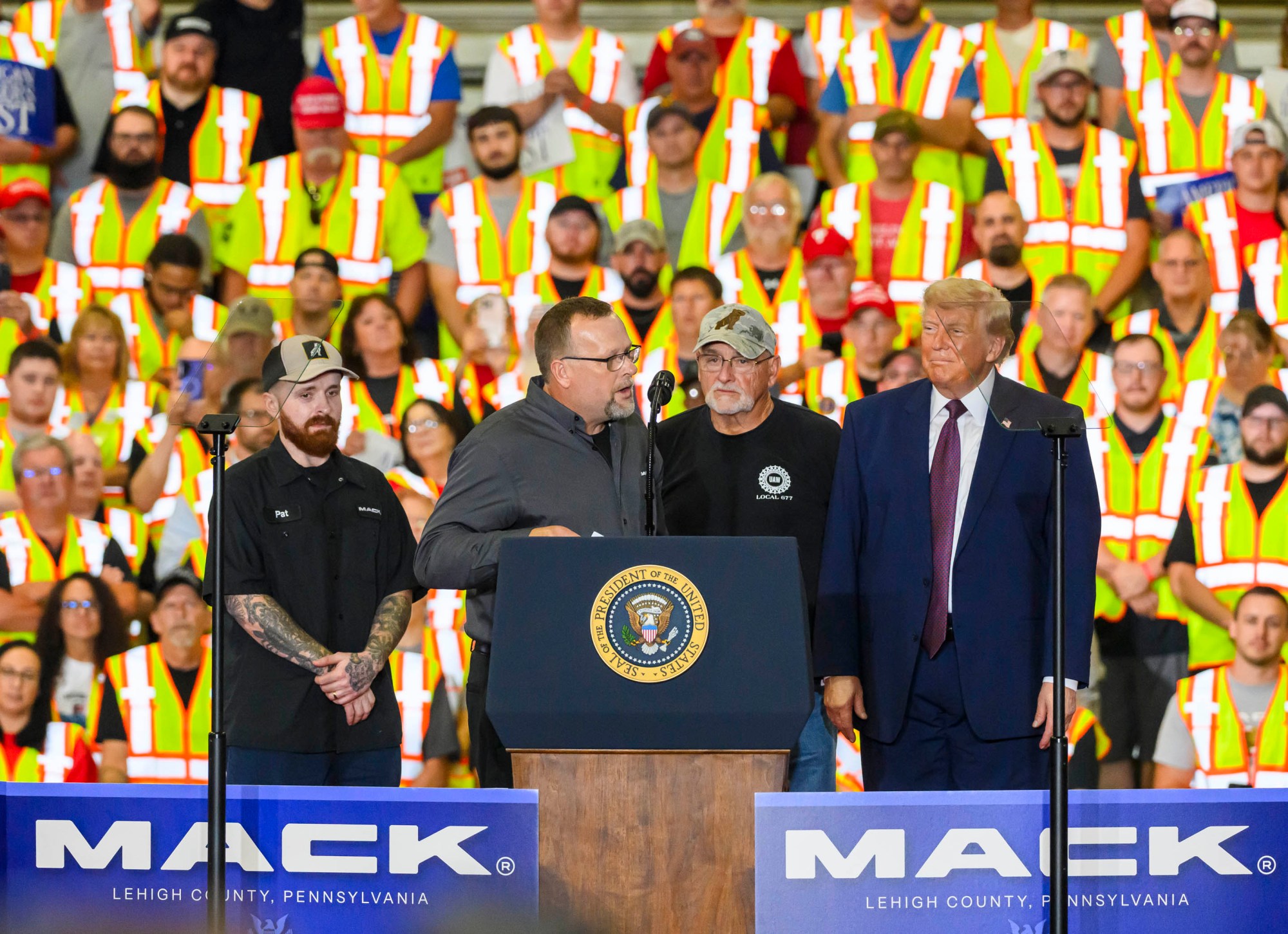 Marine Corp. veteran and longtime Mack Trucks employee Pat McHugh and his son and grandfather are called on stage by President Donald J. Trump Tuesday, June 23, 2026, at Mack Truck in Lower Macungie Township. (April Gamiz/The Morning Call)