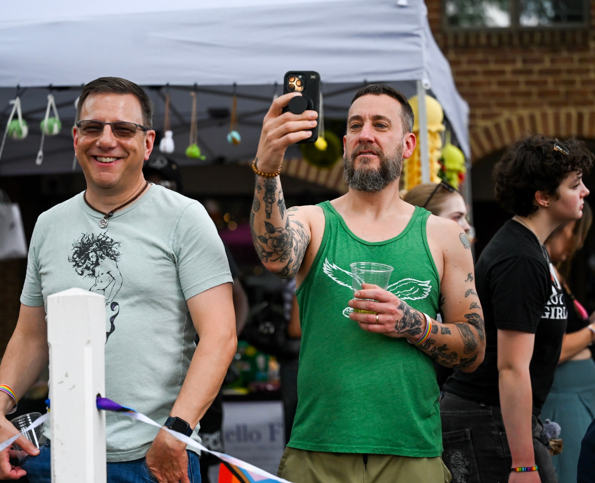 Jeremy Joiner, Brad Zuercher, and Stephen Libby watch the stage from afar Sunday, June 14, 2026, at the Pride Party Palooza in Bethlehem. (Avery Folmar/The Morning Call)