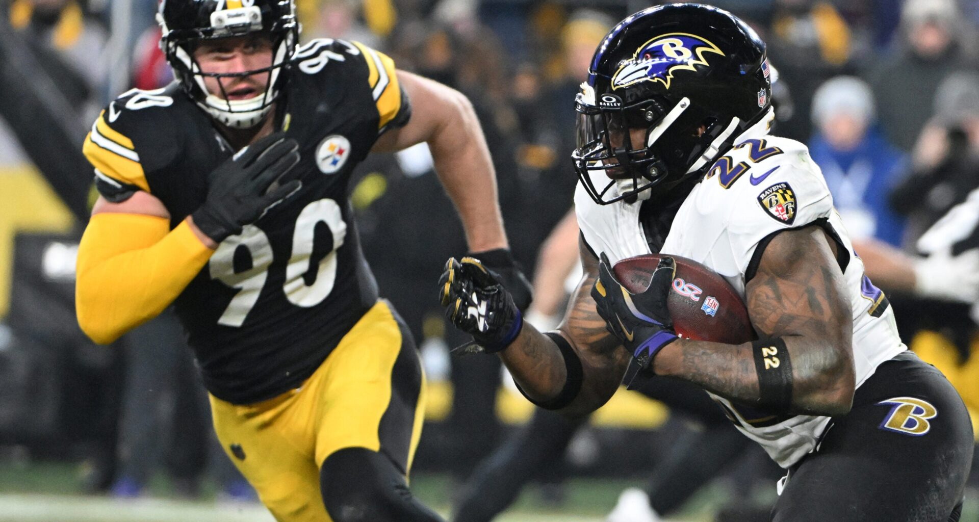 Jan 4, 2026; Pittsburgh, Pennsylvania, USA; Baltimore Ravens running back Derrick Henry (22) rushes the ball past Pittsburgh Steelers linebacker T.J. Watt (90) during the first half at Acrisure Stadium.
