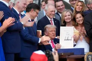 President Donald Trump holds up the "One, Big Beautiful Bill" Act that he signed into law on the South Lawn of the White House on July 4, 2025, in Washington, D.C. (Photo by Alex Brandon - Pool/Getty Images)