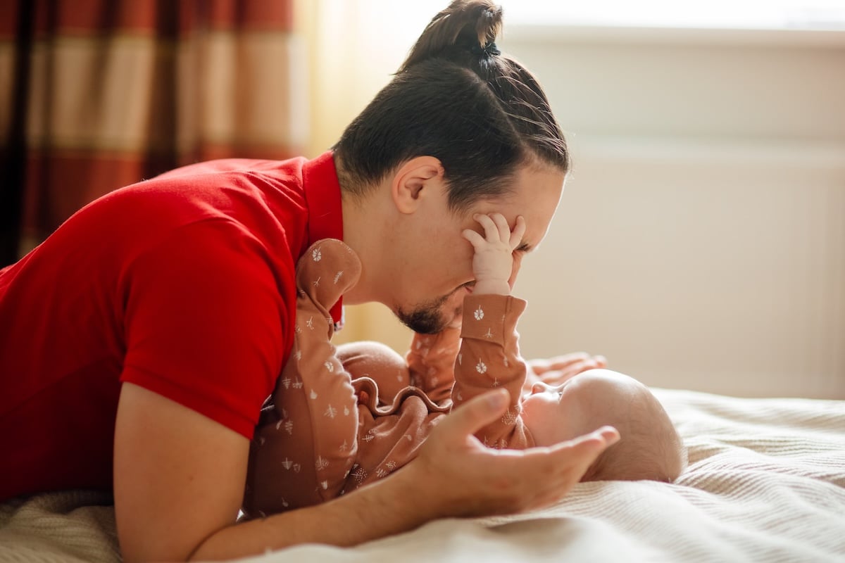 Father comforts his baby with a warm cuddle and close connection.