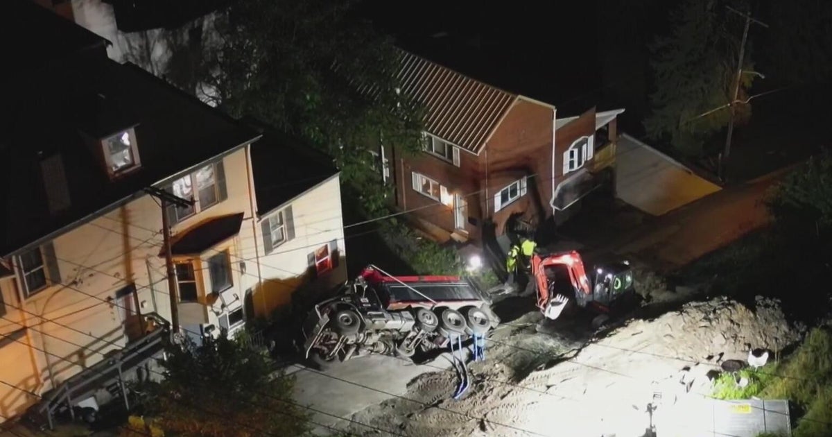 Dump truck backing down road falls into hole in Pittsburgh's Mount Washington neighborhood