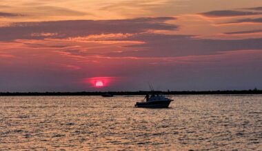A boat travels along Lake Erie as the sun sets at Wendy Park in Edgewater, Ohio. (Spectrum News 1/Lydia Taylor)