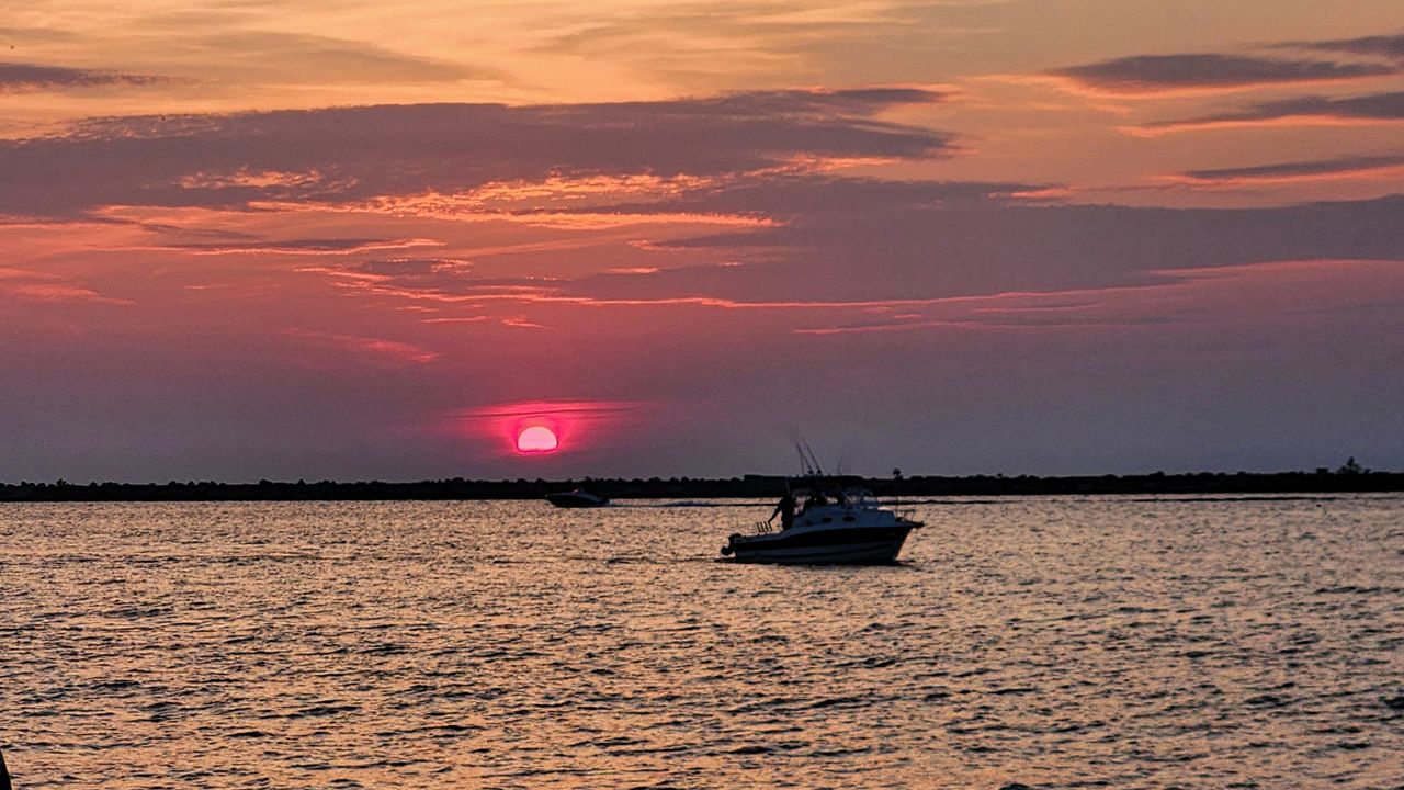 A boat travels along Lake Erie as the sun sets at Wendy Park in Edgewater, Ohio. (Spectrum News 1/Lydia Taylor)
