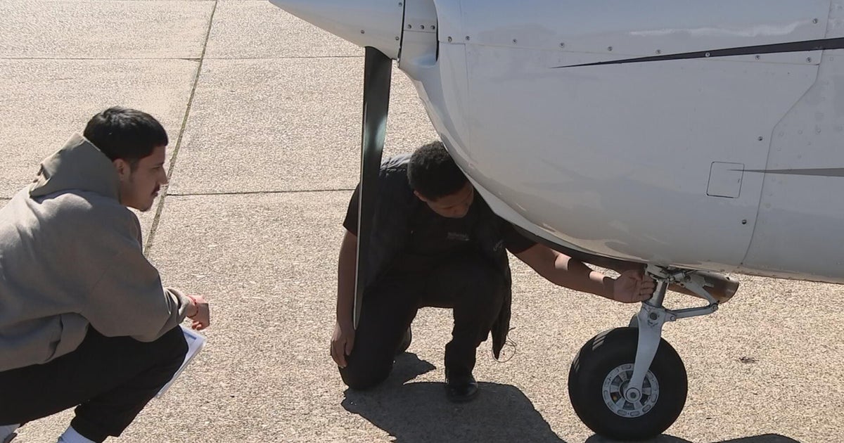 Jonathan Suarez (right) working on a plane with a fellow student