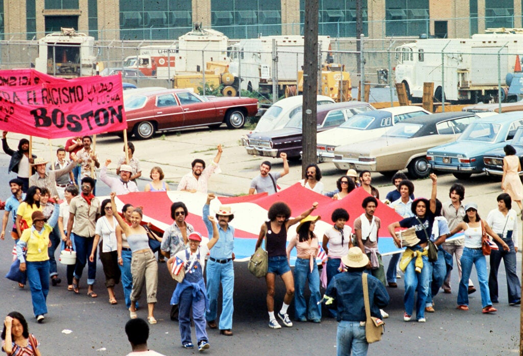 A group holds a Puerto Rican flag during a protest in 1976
