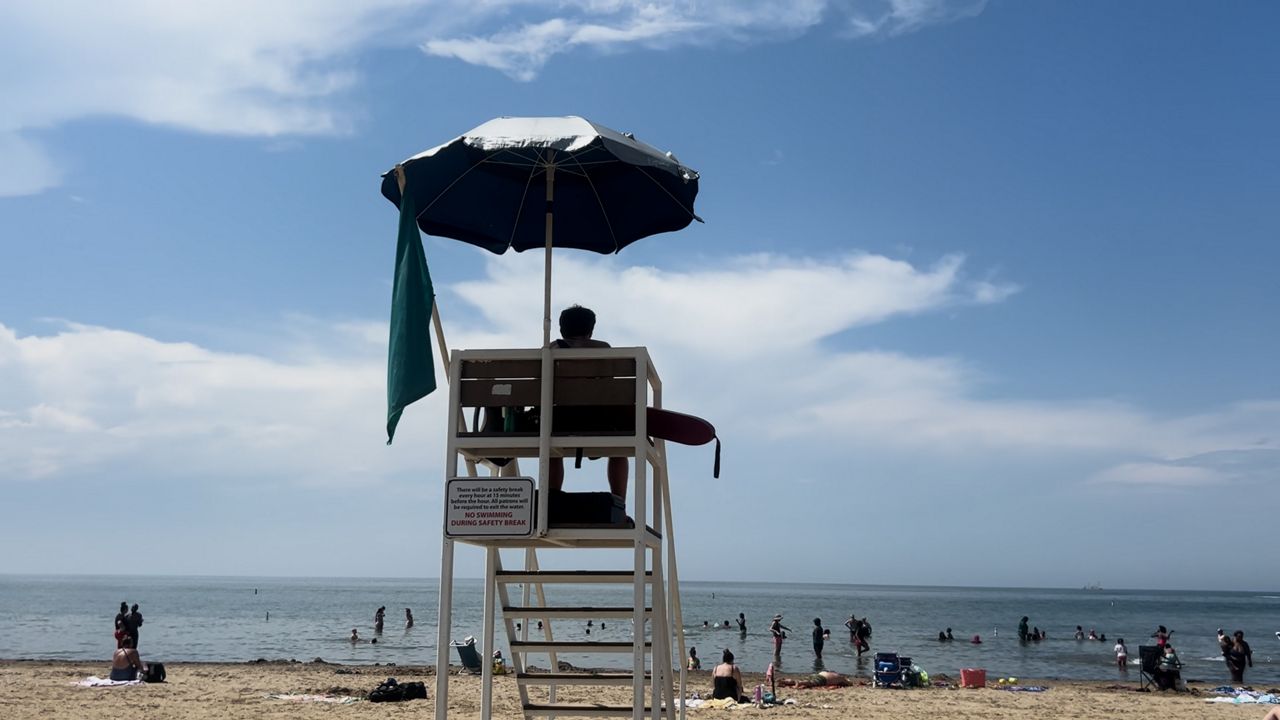 A lifeguard at Edgewater Beach watching people swim. (Spectrum News 1)