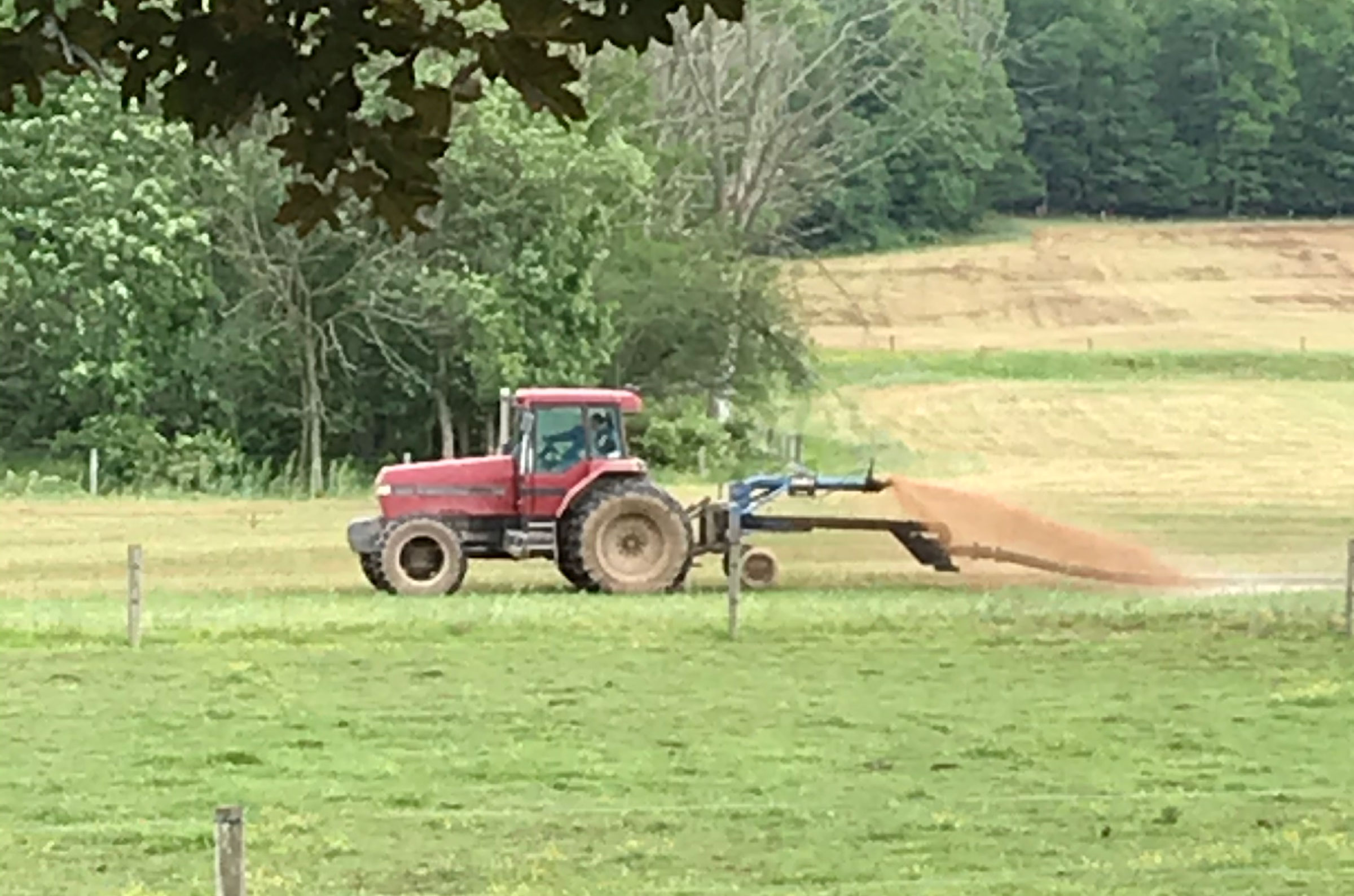 a tractor sprays slaughterhouse waste over a field