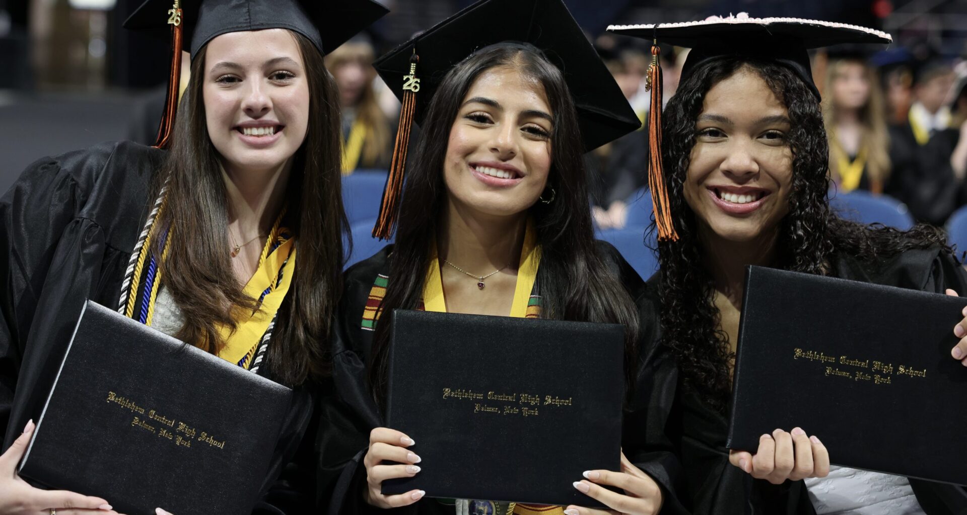 three students with diplomas