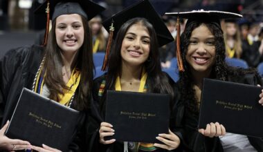 three students with diplomas