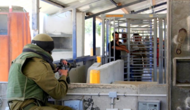 Israeli soldier faces Palestinians waiting at  Huwara checkpoint, Nablus, Wiki Image: 12.06.06