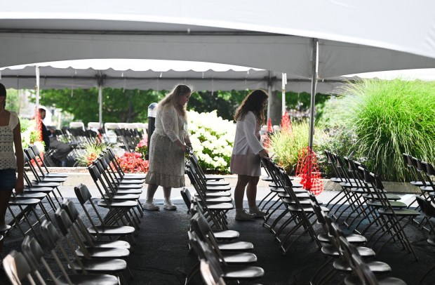 Volunteers fix the chairs underneath the tent outside before the afternoon service during St. Ann's Solemn Novena at St. Ann's Monestary and Shrine Basilica in Scranton Wednesday, July 22, 2026. (SEAN MCKEAG / STAFF PHOTOGRAPHER)