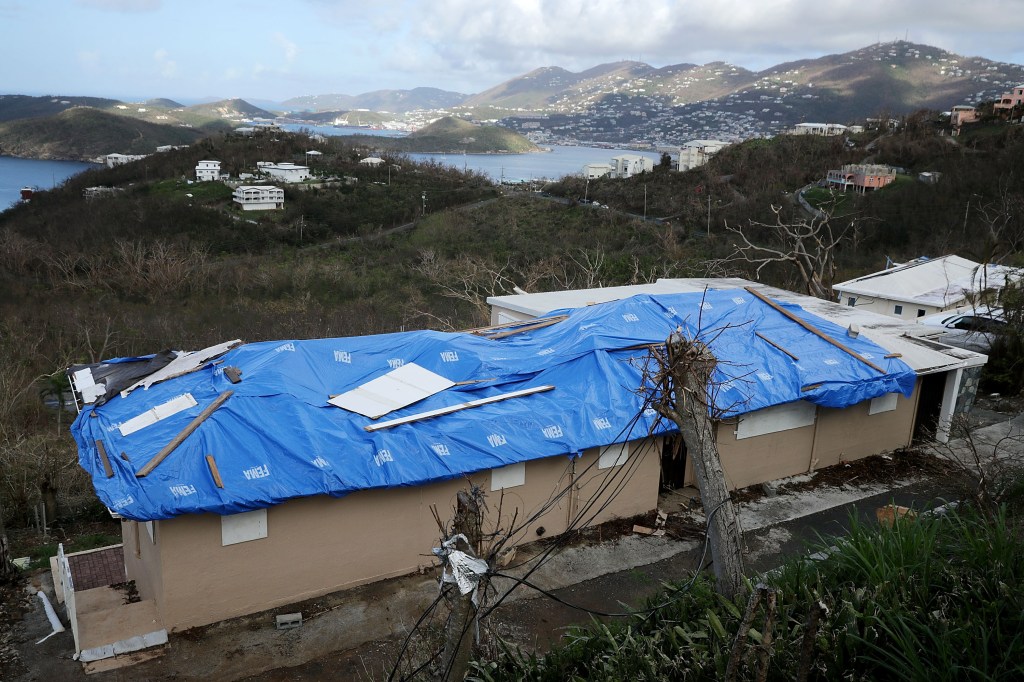 A blue tarp with the FEMA logo covers the roof of a house in the hills above Charlotte Amalie, St. Thomas, U.S. Virgin Islands, following Hurricane Irma.