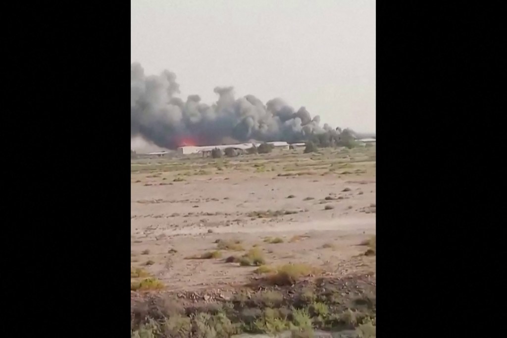 Smoke billowing from buildings at Kuwait's northern border.