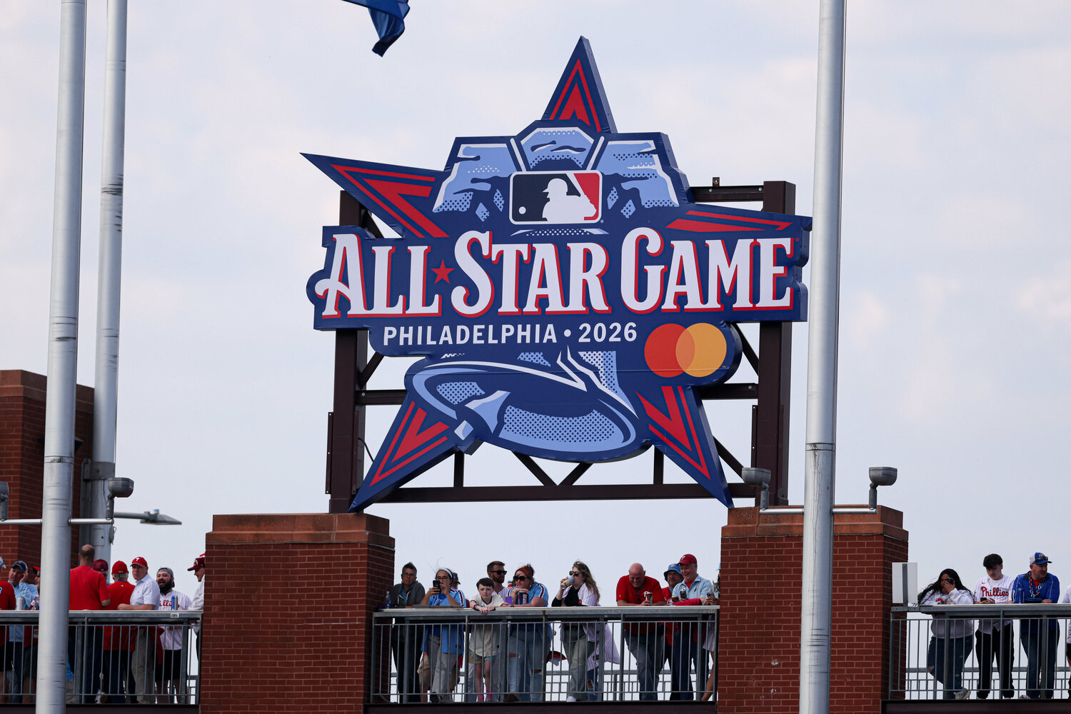 Fans stand under a 2026 All Star Game sign during a game between the Philadelphia Phillies and the Texas Rangers at Citizens Bank Park.