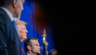 A side view of President Donald J. Trump and Secretary of War Pete Hegseth against a blue background.