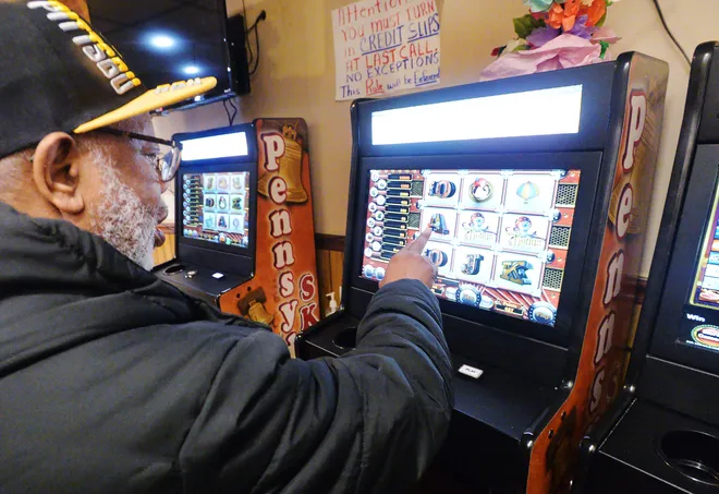 A patron of American Legion Post 771 in Erie points out a bonus roll while playing a Pennsylvania Skills game.