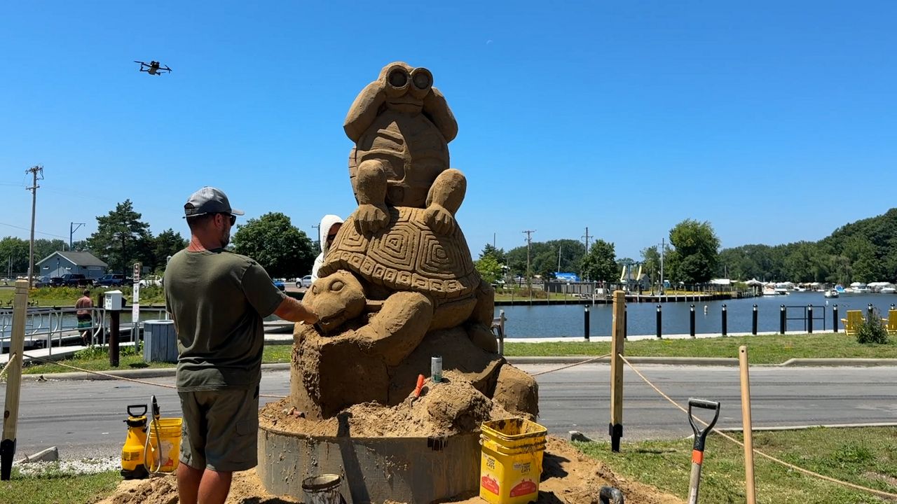 Sand sculptors Carl Jara and Greg J. Grady work on a sand sculpture ahead of the 2nd Lake Erie Sand Sculpture Tour in Lake County.