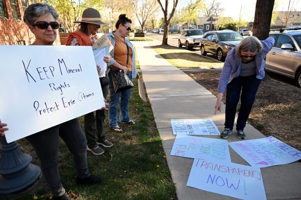 Protesters and signs outside the Erie Town Hall in April. (Joel Solis/Staff Photographer)