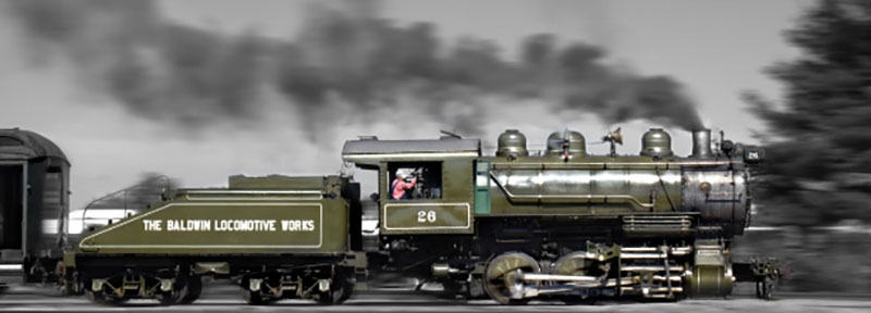 A green locomotive ateams along the tracks at Steamtown National Historic Site in Scranton, PA.