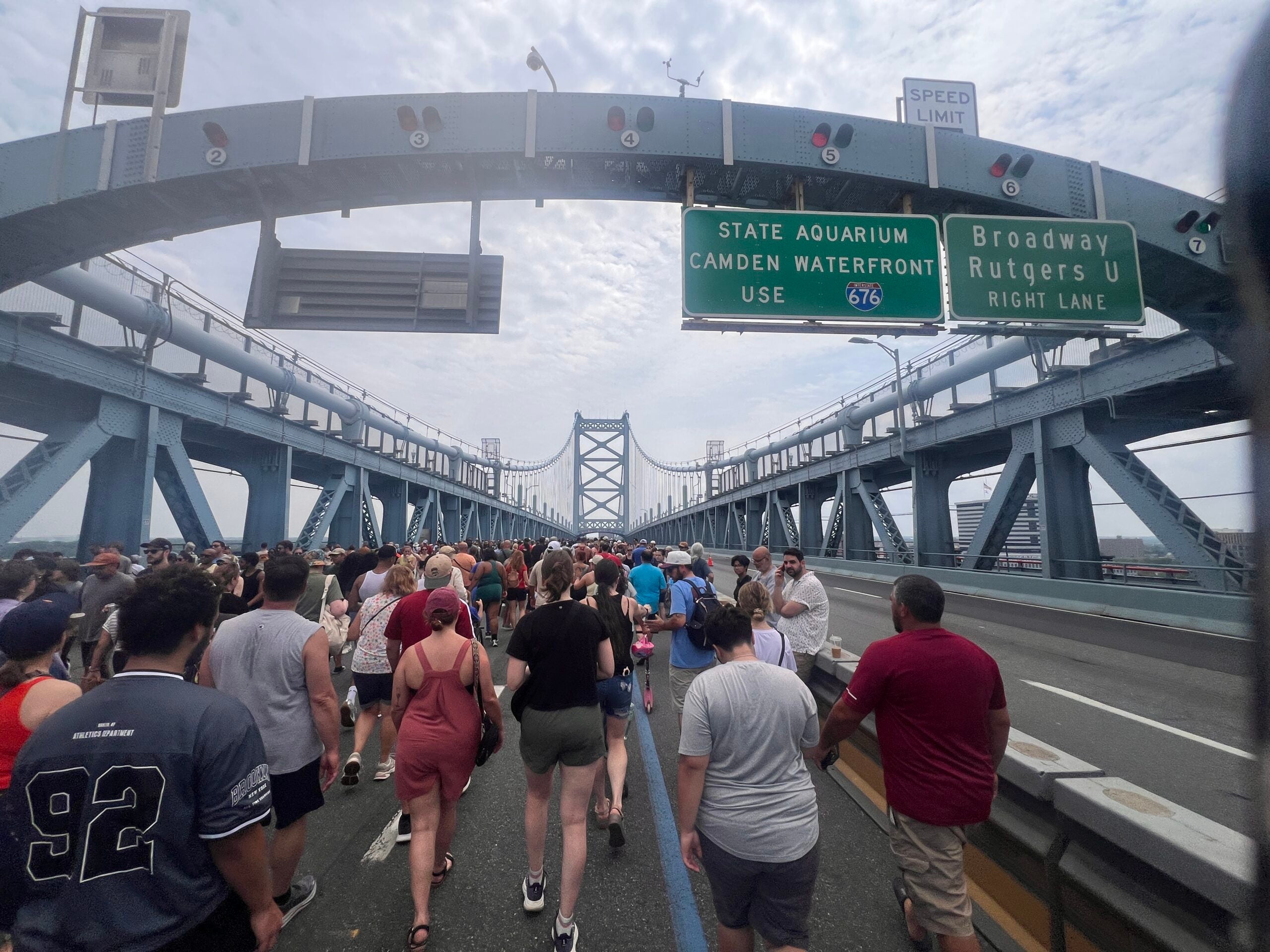 Thousands of people crowd one side of the Ben Franklin Bridge to walk over for the 100th Anniversary celebration.