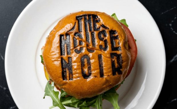 A burger branded with The House Noir sits on a plate (Courtesy of Zach Neil)