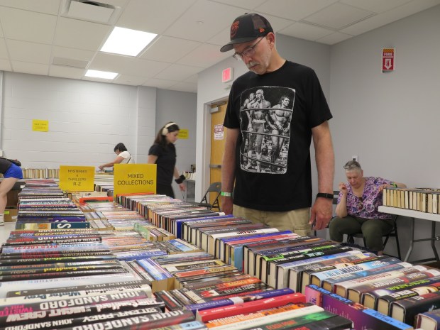 Mike Amberman, of southern York County, checks out the selections during the opening day of the 2026 Berks Book Bonanza. (DAVID MEKEEL - READING EAGLE)
