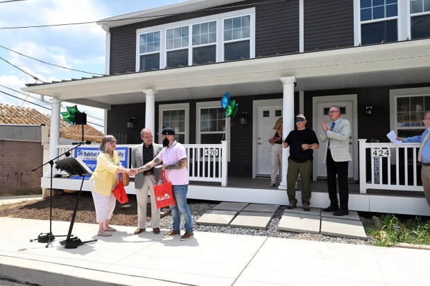 Reading City Council President Donna Reed and Councilman Chris Miller present new homeowner Obal with gifts during a Habitat for Humanity house dedication in the 400 block of Miltimore Street on Monday, June 29, 2026. (BILL UHRICH/READING EAGLE)
