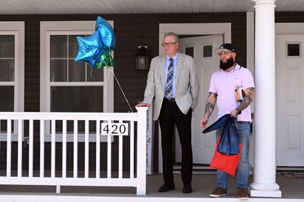 Habitat for Humanity Executive Director Tim Daley, left, and Obal check the view from Obal's new home during the organization's house dedication in the 400 block of Miltimore Street on Monday, June 29, 2026. (BILL UHRICH/READING EAGLE)