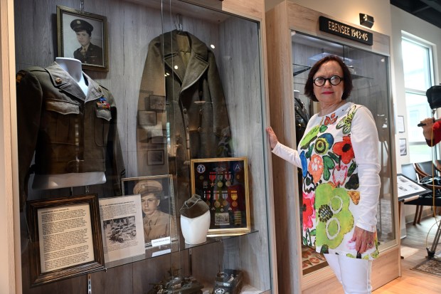 Susan Atkins Weiser of Spring Township stands with the display honoring her father, Carthell Bennett Atkins, who was a tanker in George Patton's Third Army and helped liberate the Ohrdruf concentration camp, at the Berks Holocaust Education Center Museum in Mohnton on Thursday, July 16, 2026. (BILL UHRICH/READING EAGLE)