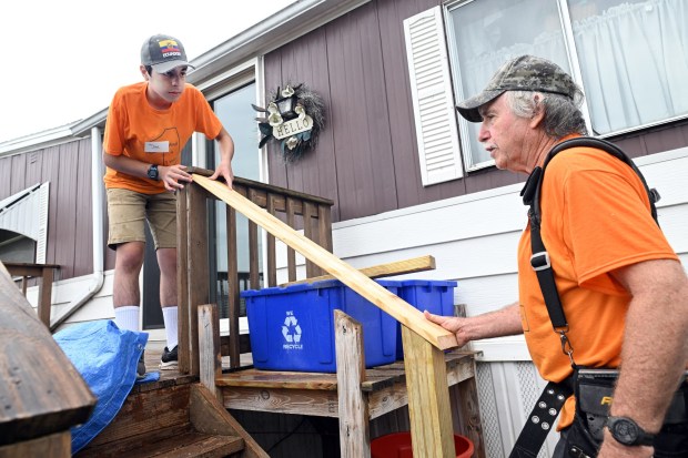 Caleb Sotomayor, 15, of Douglassville, installs a deck railing with Mark Hile of Pike Township at a Mission Trip Birdsboro work site at Valley View in Amity Township on Saturday, July 19, 2025. (BILL UHRICH/READING EAGLE)