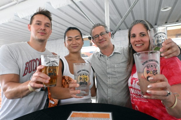 Raising a pint are, from left, Josh and Laura Auman of Douglassville and Jess and Melissa Yourkavitch of Mount Penn during Pints for Pups at Classic Harley Davidson on Saturday, July 18, 2026. (BILL UHRICH/READING EAGLE)