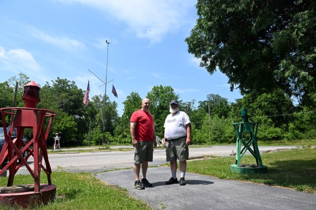 The Reading Flotilla Training Base at 2058 River Road will be closing. Mike McElwee of Wyomissing, base director, and James White of Exeter Township, president of the board, stand between two buoys at the base. (BILL UHRICH/READING EAGLE)