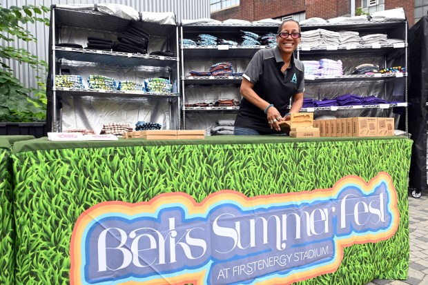 Tish Davis, executive director of the Berks Arts Council, arranges merchandise during Berks SummerFest at the GoggleWorks Center for the Arts on Saturday, July 11, 2026. (BILL UHRICH/READING EAGLE)