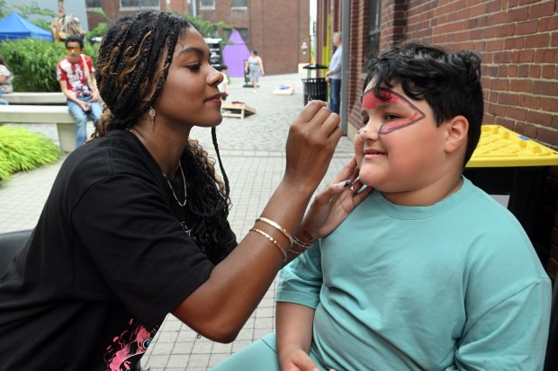 Articst Alexis Marrero of Reading paints the face of Silas Iglesisas, 7, during Berks SummerFest at the GoggleWorks Center for the Arts on Saturday, July 11, 2026. (BILL UHRICH/READING EAGLE)