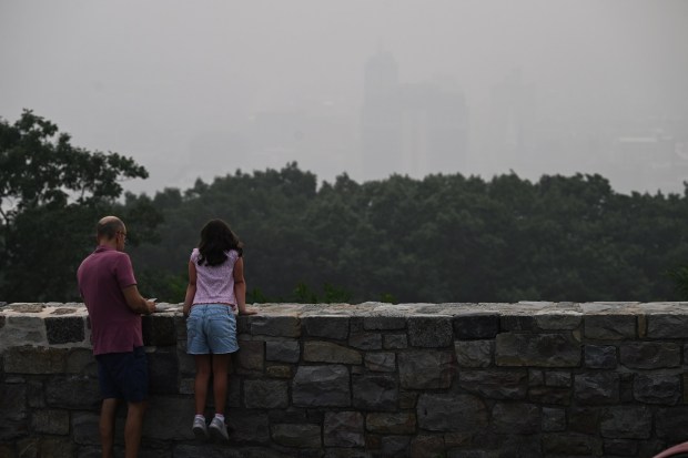 A father and daughter at a lookout at the Pagoda can barely see downtown Reading on Thursday, July 16, 2026. (BILL UHRICH/READING EAGLE)